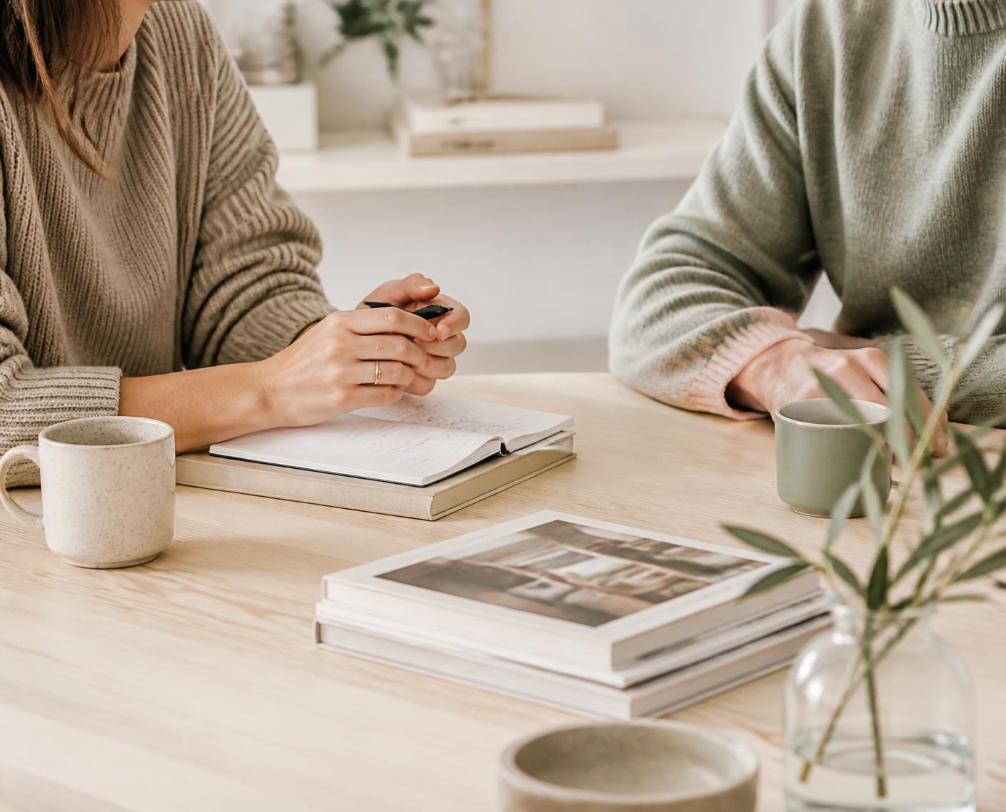 Two colleagues working through notes together at a table